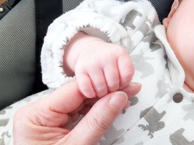 母親の指を握る赤ちゃん