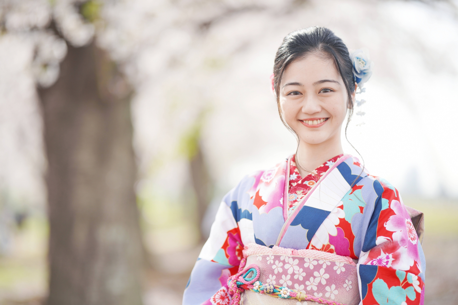 桜の木の前で笑っている女性