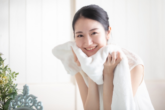 洗顔後タオルで顔を拭いている女性