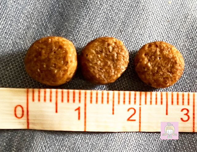 マックアダムズドッグフード チキンの粒の大きさをメジャーで測っているところ。